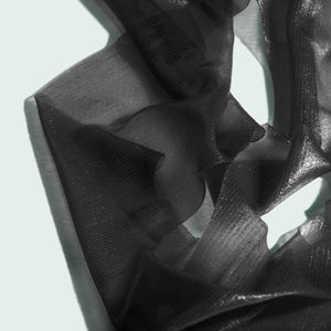 Close-up of translucent black hydrogel sheet mask material with delicate texture and folds, representing I MASK hydrating hydrogel sheet mask (5 pack) | IMAGE Skincare.