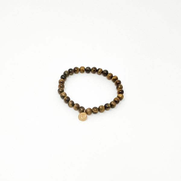 Assorted Satya Bracelets | Satya featuring a round beaded design with natural brown tones and a small circular charm on a white background.