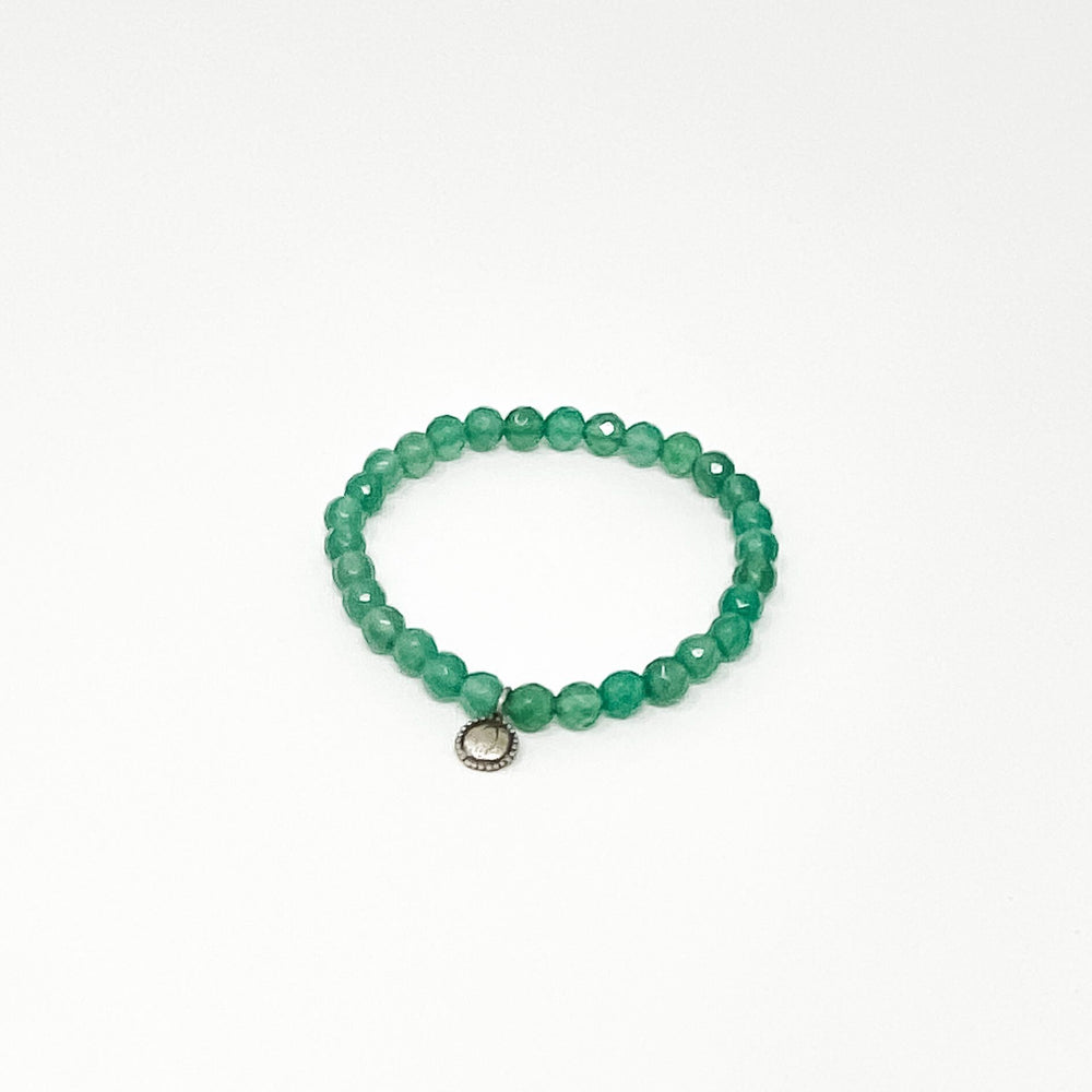 Assorted Satya Bracelets | Satya featuring a single circular bracelet made of polished reddish-brown beads with one small golden bead on a white background.