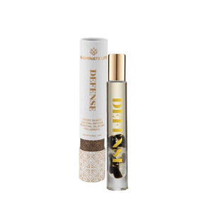 Defense RollerBall | Aluminate Life essential oil blend in a clear glass roller bottle with gold cap, next to its white and gold decorative packaging, promoting wellness and skincare.