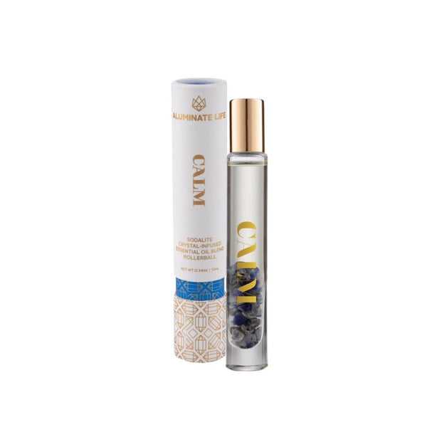 Calm RollerBall | Aluminate Life with clear glass rollerball bottle containing blue sodalite crystals and matching white and gold cylindrical packaging for wellness and skincare.