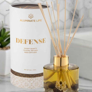 Defense Reed Diffuser | Aluminate Life featuring a smoky quartz crystal-infused amber glass bottle with natural reed sticks, designed for home wellness and ambient fragrance.