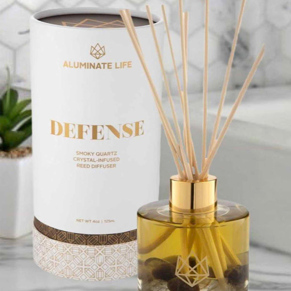 Defense Reed Diffuser | Aluminate Life featuring a smoky quartz crystal-infused amber glass bottle with natural reed sticks, designed for home wellness and ambient fragrance.