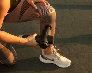 Person using Hypervolt 2 Pro | Hyperice massage device on their leg outdoors, demonstrating a recovery tool for muscle relief and wellness.