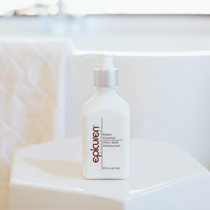Bottle of Kukui Coconut After Bath Moisturizer | Epicuren Discovery with a pump dispenser placed on a white surface in a bright bathroom setting.