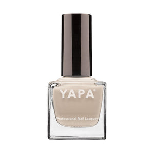 A neutral beige nail polish bottle with a black cap labeled Kelly Nail Lacquer | YAPA, designed for professional manicure use.