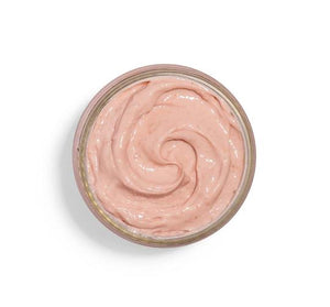 Top view of creamy light pink skincare mask texture in a round jar, showcasing Mighty Brighty™ Vitamin C + Chamomile Brightening Mask | Farmhouse Fresh for gentle brightening and skincare wellness.