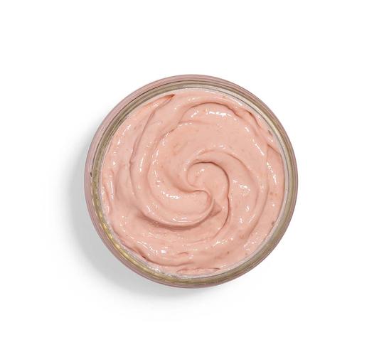 Top view of creamy light pink skincare mask texture in a round jar, showcasing Mighty Brighty™ Vitamin C + Chamomile Brightening Mask | Farmhouse Fresh for gentle brightening and skincare wellness.