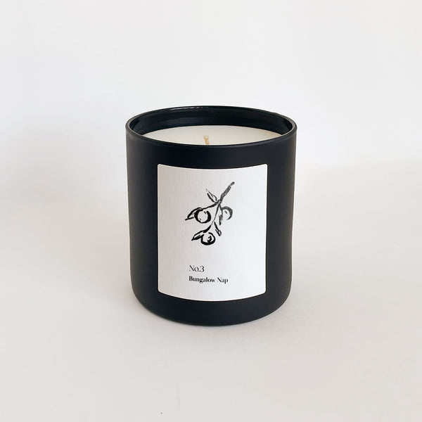 Minimalist black candle jar with a simple white label featuring an olive branch illustration, showcasing the No. 3 Bungalow Nap (Fiji) Candle | Lucky Owl.