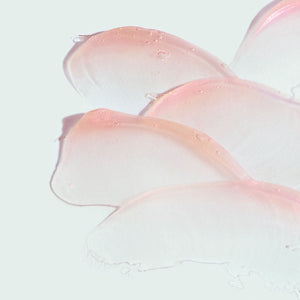 Close-up of smooth, translucent lip balm swatches in a soft pink tint with a glossy finish, representing ORMEDIC sheer pink lip enhancement complex | IMAGE Skincare.