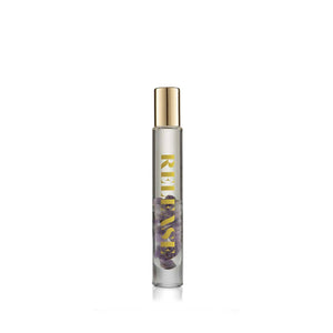 Clear glass rollerball bottle with small purple stones inside and gold cap, labeled Release Essential Oil Rollerball | Aluminate Life, designed for wellness and body care.