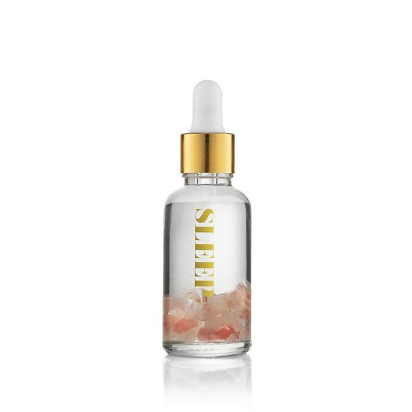 Clear glass vial filled with pink crystals and transparent liquid, topped with a gold dropper cap, labeled Sleep Essential Oil Vial | Aluminate Life for wellness and relaxation.