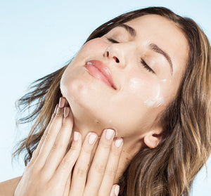Woman gently applying Three Milk Ageless Sleep Cream with Peptides | Farmhouse Fresh to her face, showcasing glowing, hydrated skin and a serene expression.