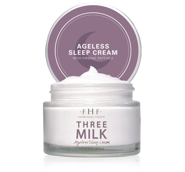 Open jar of Three Milk Ageless Sleep Cream with Peptides | Farmhouse Fresh showing smooth white skincare cream inside and purple lid with product name and crescent moon design.