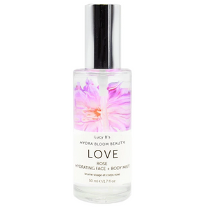 Clear glass bottle of Hydra Bloom Love Rose Face and Body Mist | Hydra Bloom with pink floral design and silver spray cap, a hydrating skincare product.