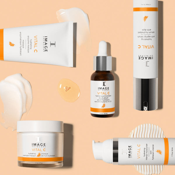 Assorted VITAL C hydrating enzyme masque | IMAGE Skincare products including cream, serum, and lotion with smooth creamy and gel textures displayed on a soft peach background.