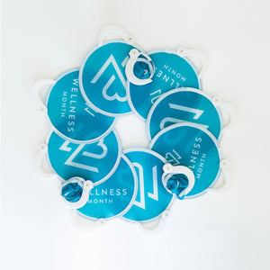 A collection of blue circular handheld fans with white handles laid out in a circle, each displaying the text Wellness Month, featuring the Wellness Month Fan 10-Pack | Wellness Month.