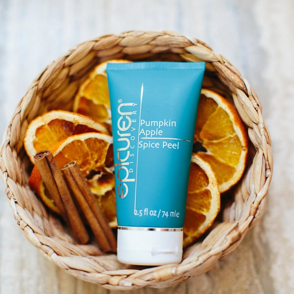 Pumpkin Apple Spice Peel | Epicuren Discovery tube in a woven basket with dried orange slices and cinnamon sticks, highlighting natural skincare ingredients.